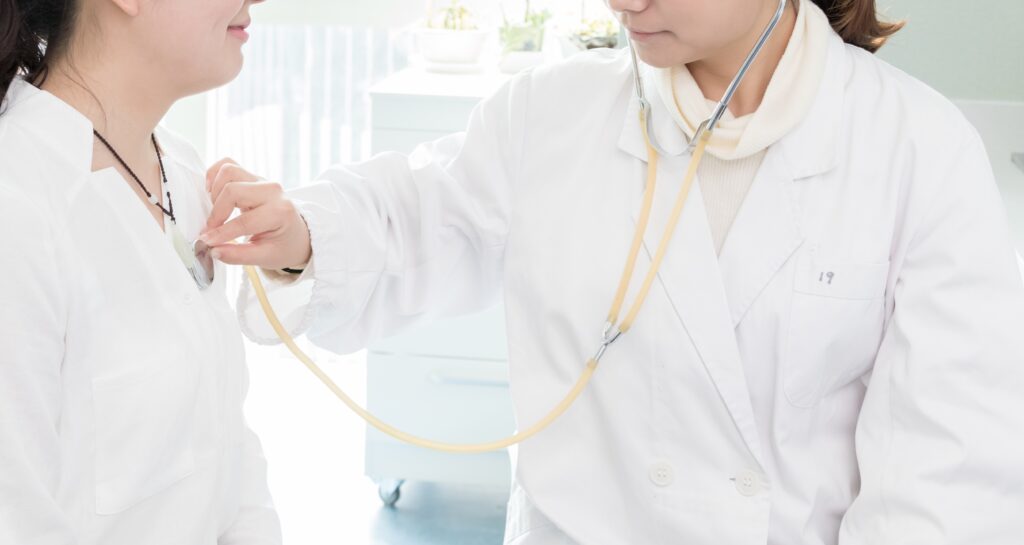 Female doctor examining patient with stethoscope